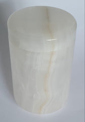 White honey onyx stone urn on a light gray background