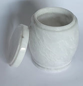 White marble-patterned jar urn with lid on a light gray background