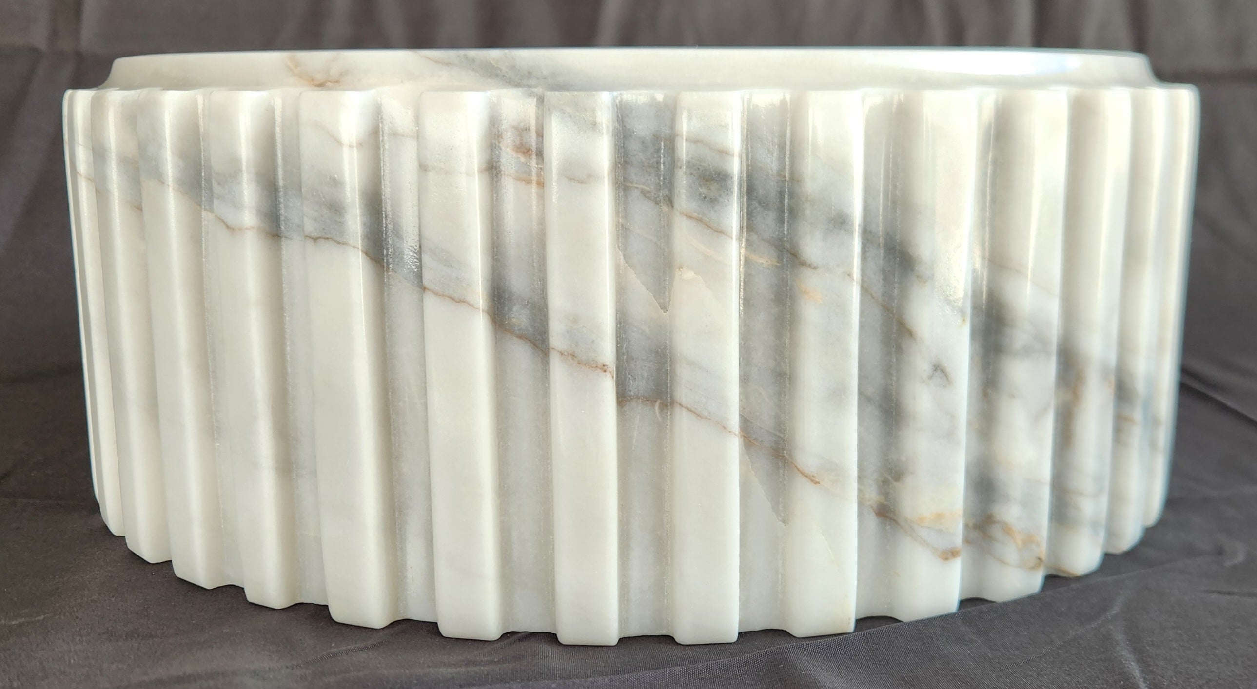 Marble-patterned cylindrical object on a dark background