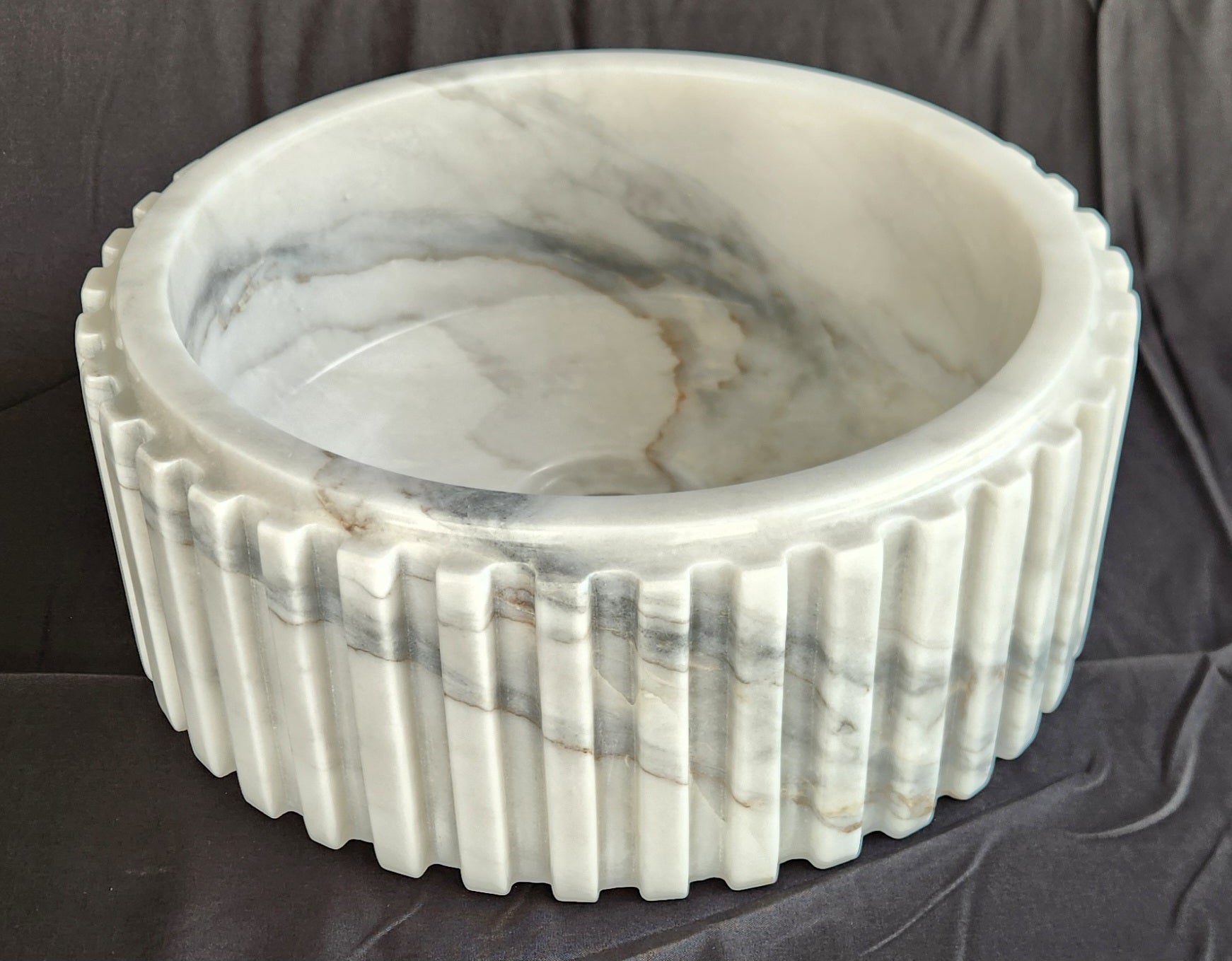 Marble-patterned stone bowl on a dark surface