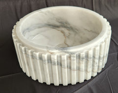 Marble-patterned stone vessel sink bowl on a dark surface