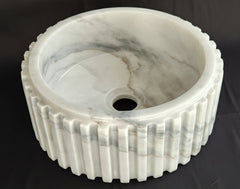 Carrara Marble sink with gray veining on a black background