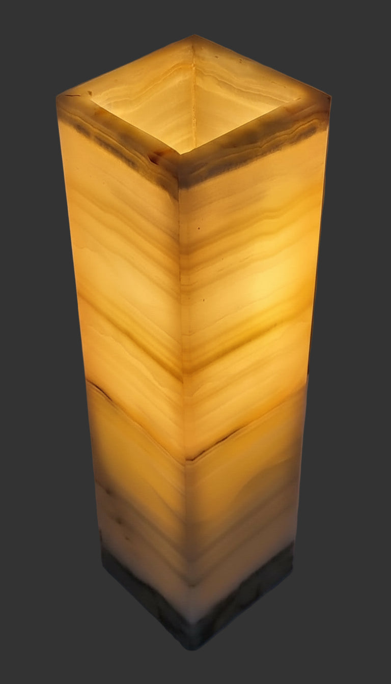 Square-shaped lamp with a warm glow on a plain background
