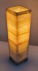 Square-shaped onyx lamp with a warm glow on a plain background
