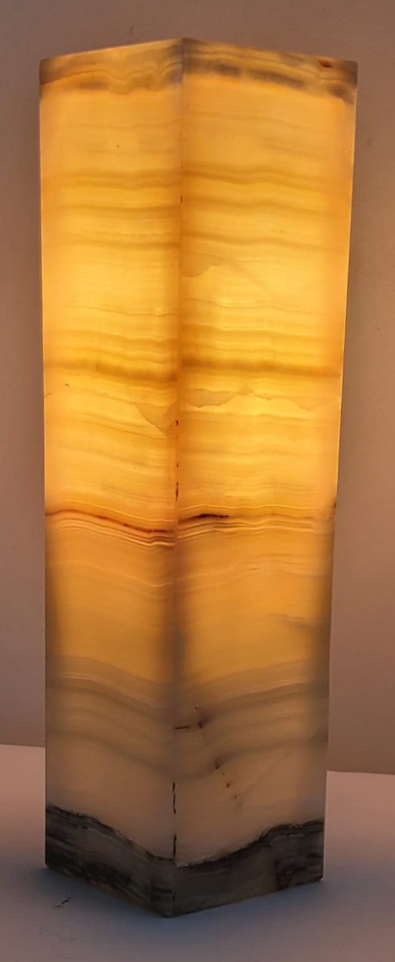 Decorative stone lamp with a textured, multicolored design on a plain background