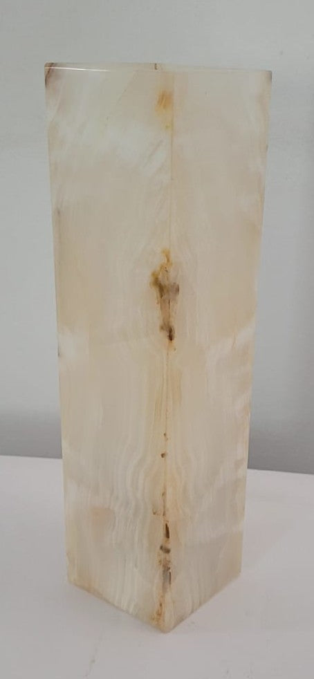 Rectangular block of light-colored stone with natural texture on a white background
