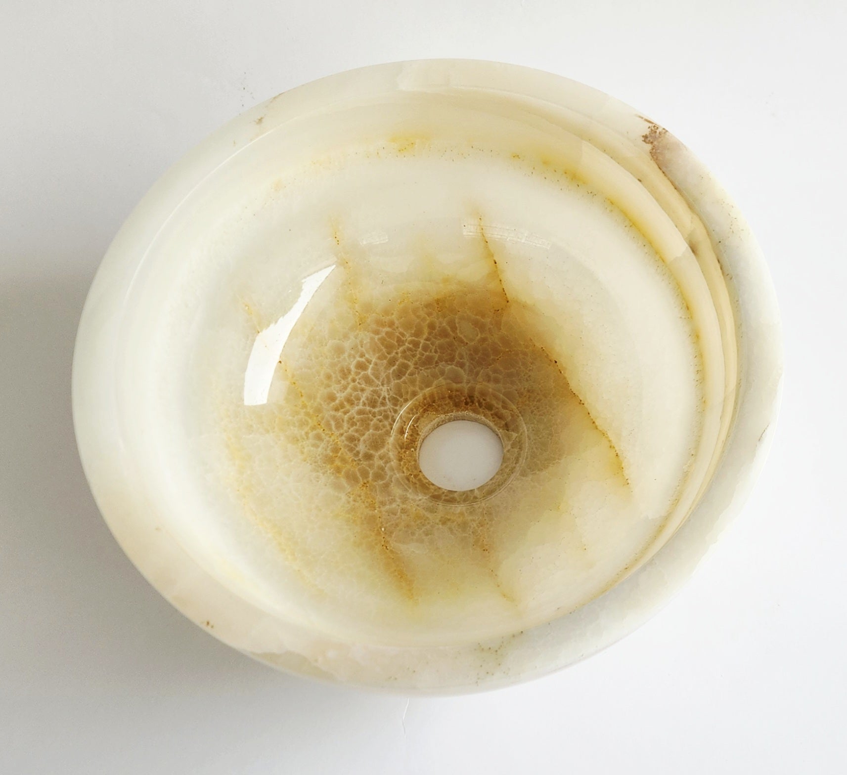 Round white onyx stone with a central hole on a white background