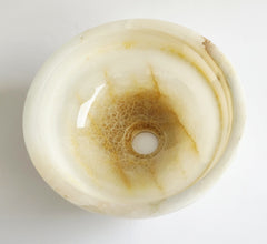 Round white onyx stone with a central hole on a white background