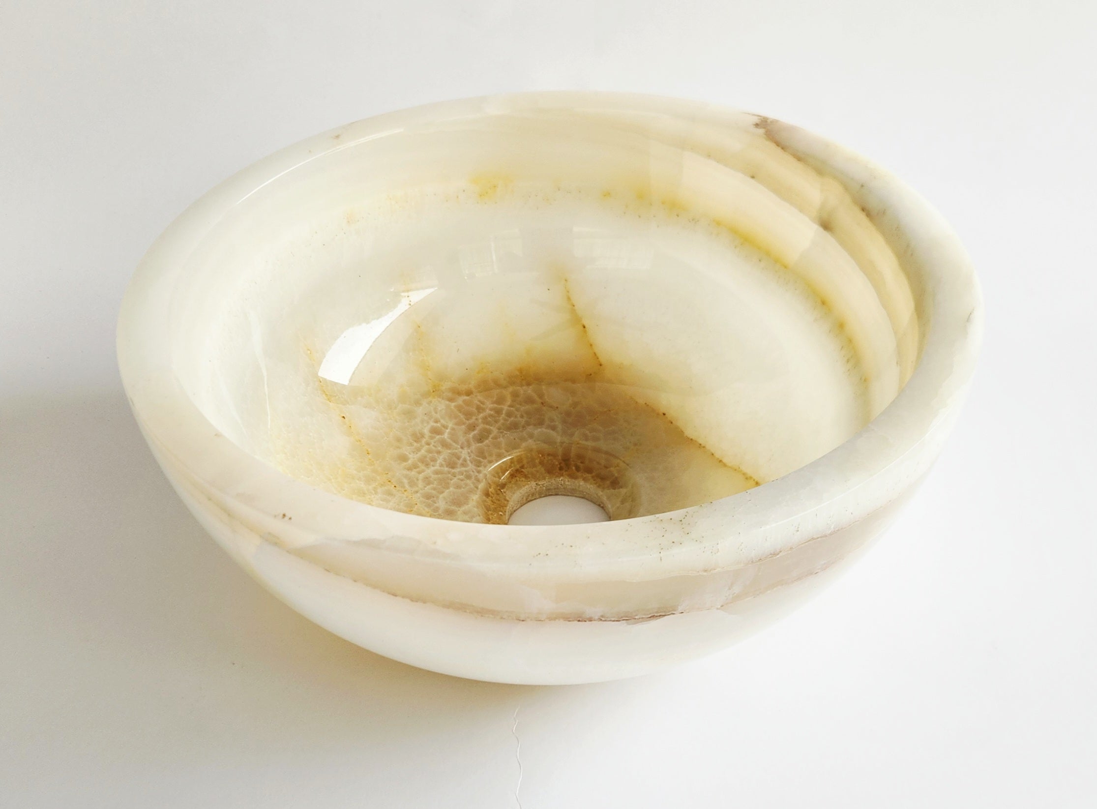 White onyx bowl with natural patterns on a light gray background